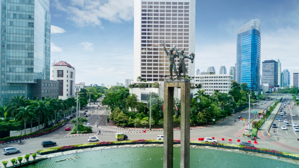 Aerial view of Jakarta’s Welcome Monument, office towers, and busy roads, showing the capital as a key hub for foreigners buying property in Indonesia and investing in urban real estate.