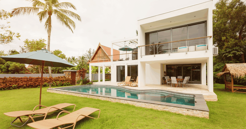 Modern white villa with a private pool, garden, and sun loungers in Bali